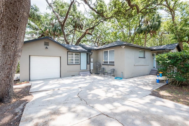 1310 Hilton Pl, Tampa, FL 33604 - ranch-style home featuring an attached garage, stucco siding, driveway, and entry steps