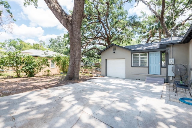 1310 Hilton Pl, Tampa, FL 33604 - view of property exterior featuring entry steps, a garage, stucco siding, and concrete driveway