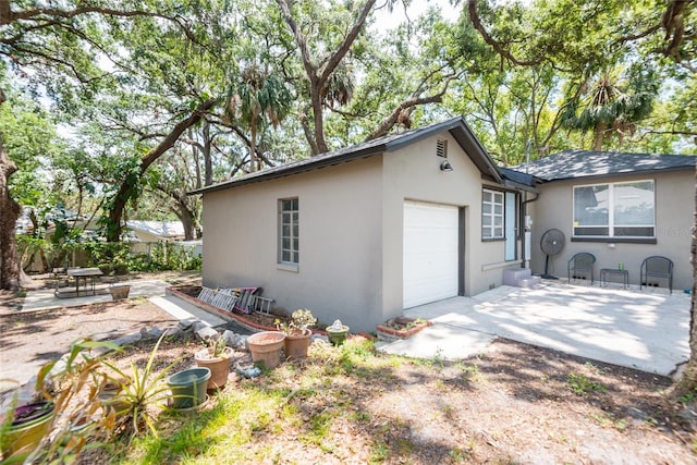 1310 Hilton Pl, Tampa, FL 33604 - view of home's exterior with a patio, a garage, stucco siding, fence, and driveway