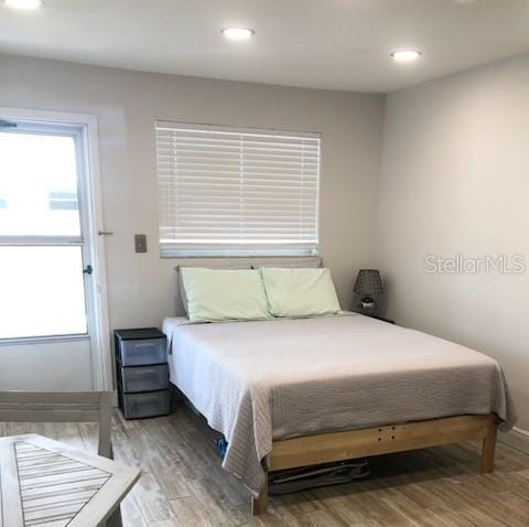 bedroom featuring wood finished floors, baseboards, and recessed lighting