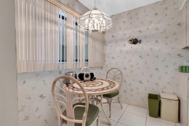 dining space featuring a chandelier, baseboards, wallpapered walls, and tile patterned floors