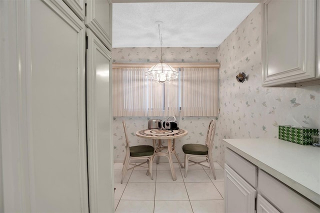 dining space featuring light tile patterned floors, a chandelier, and wallpapered walls