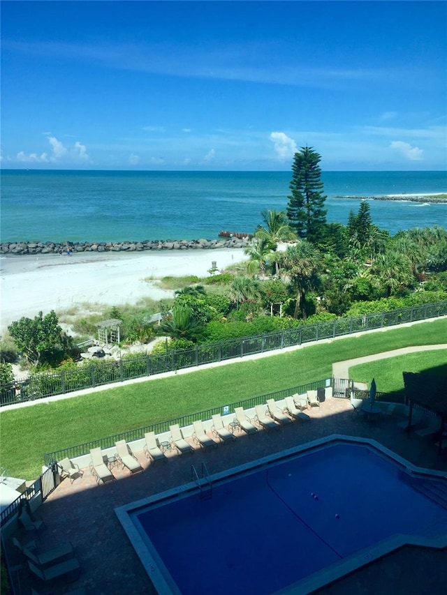 property view of water with a fenced backyard and a view of the beach