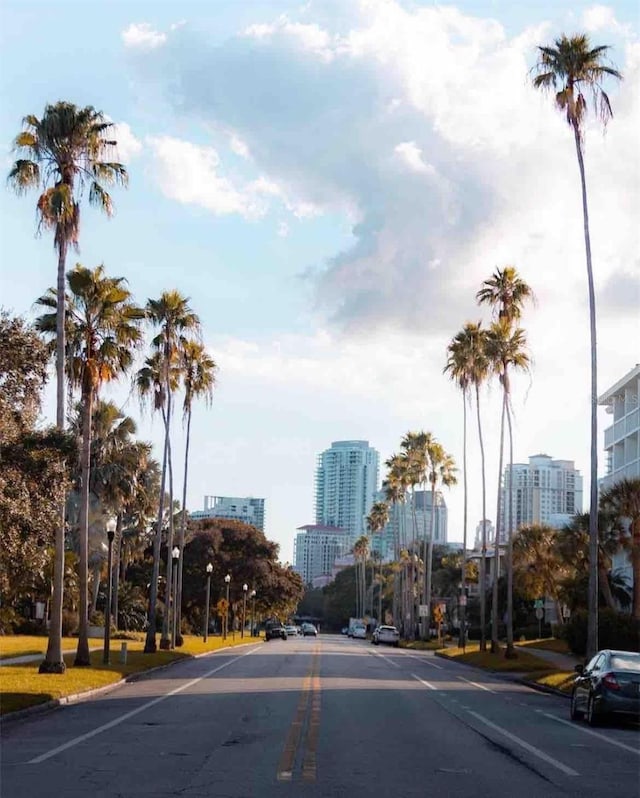 view of street featuring street lights, a city view, and curbs