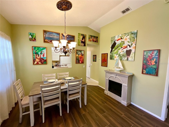 4740 Carrington Ct Unit 4740, New Port Richey, FL 34655 - dining area featuring lofted ceiling, a chandelier, dark wood-style floors, baseboards, and a fireplace