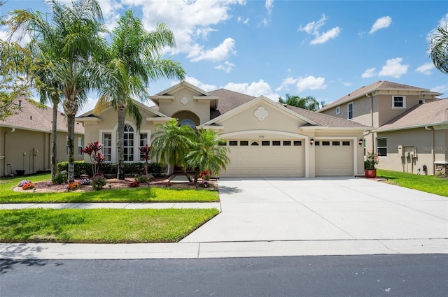 3300 Stonegate Falls Dr, Land O Lakes, FL 34638 - mediterranean / spanish-style house featuring a garage, concrete driveway, a front lawn, and stucco siding