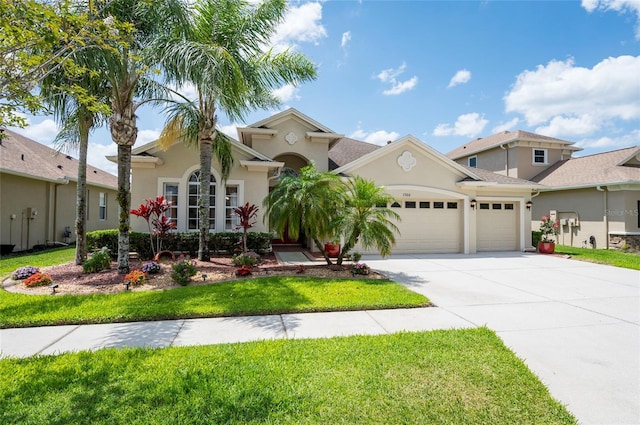3300 Stonegate Falls Dr, Land O Lakes, FL 34638 - mediterranean / spanish home featuring a garage, driveway, stucco siding, and a front yard