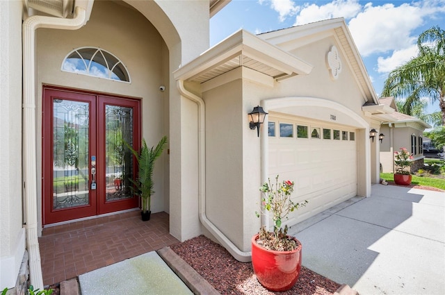3300 Stonegate Falls Dr, Land O Lakes, FL 34638 - property entrance with french doors, stucco siding, concrete driveway, and a garage