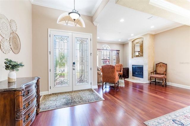 3300 Stonegate Falls Dr, Land O Lakes, FL 34638 - foyer entrance with french doors, wood finished floors, a tiled fireplace, ornamental molding, and baseboards