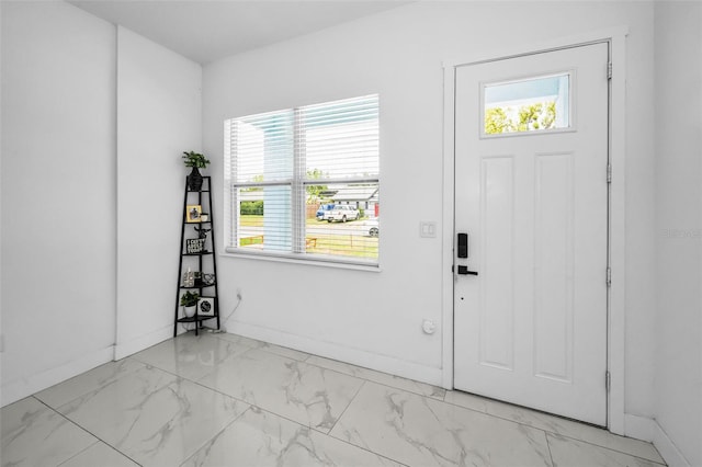 entryway featuring marble finish floors and baseboards