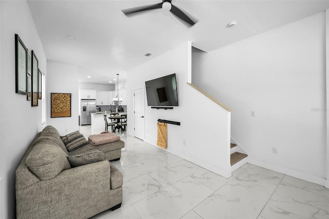 living area featuring a ceiling fan, stairs, light marble finish flooring, baseboards, and recessed lighting