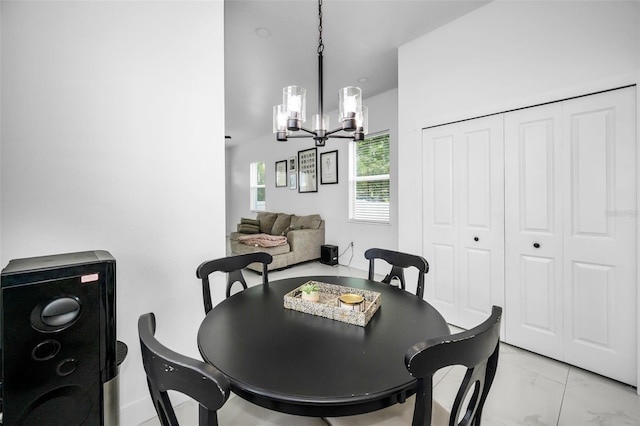 dining space with a chandelier and light marble finish floors