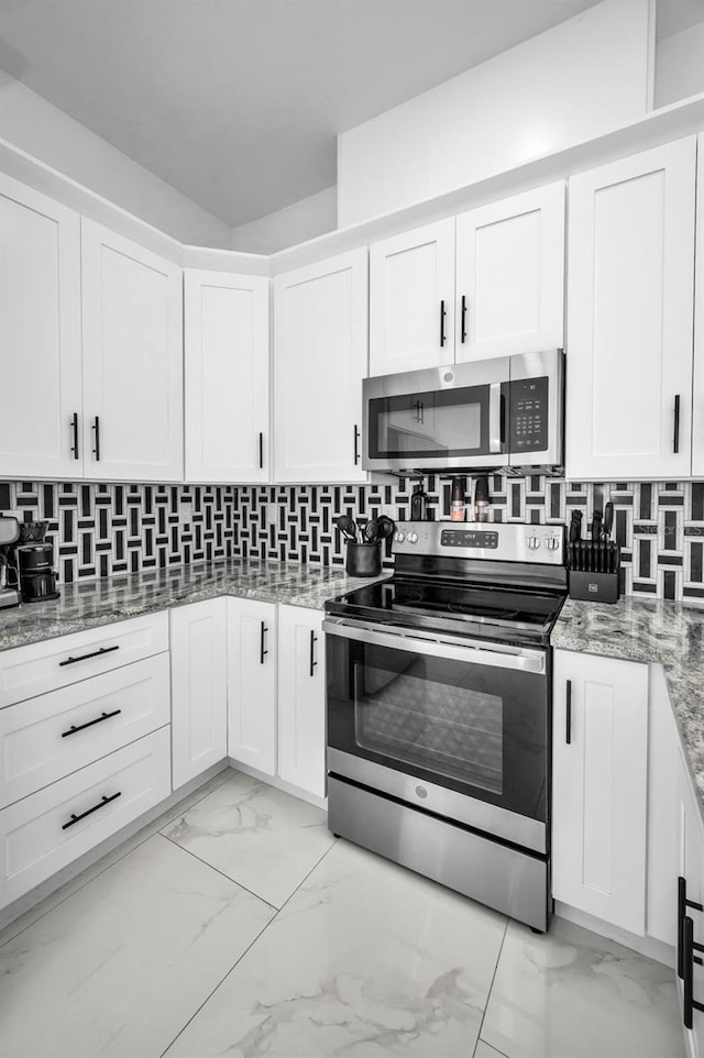 kitchen with stainless steel appliances, light marble finish floors, and white cabinetry
