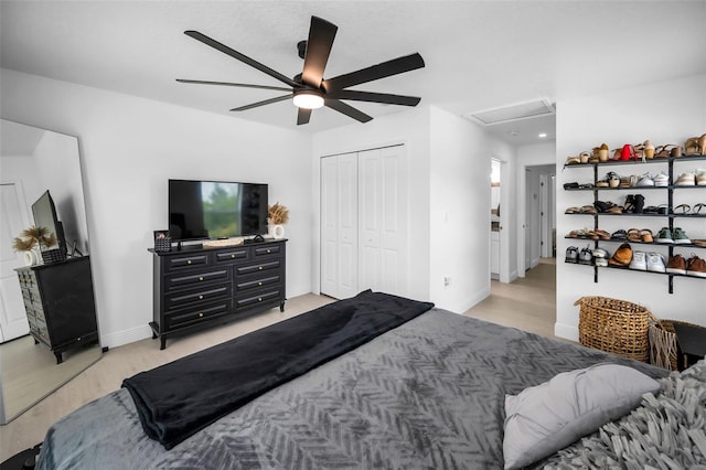 bedroom with light wood-style flooring, a closet, a ceiling fan, and baseboards