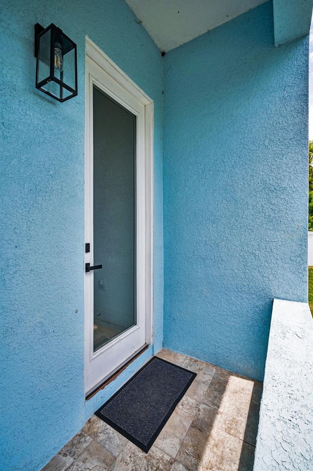 entrance to property featuring stucco siding