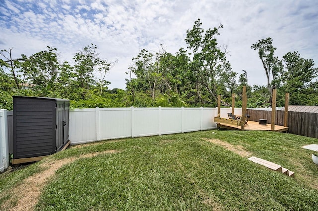 view of yard with a deck, a shed, and an outdoor structure