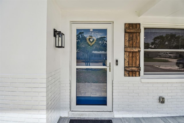 doorway to property featuring brick siding