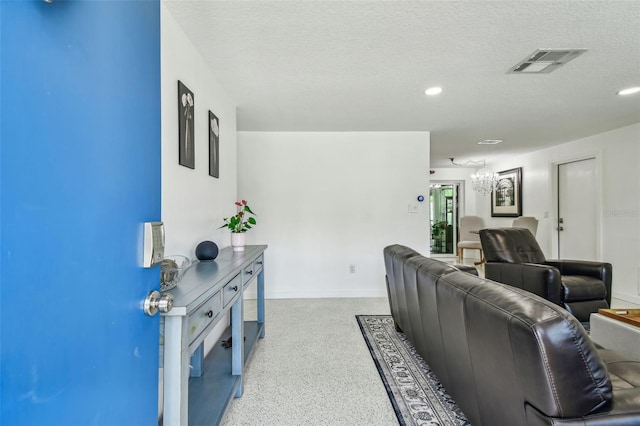 living area featuring speckle patterned floor, a chandelier, a textured ceiling, recessed lighting, and baseboards