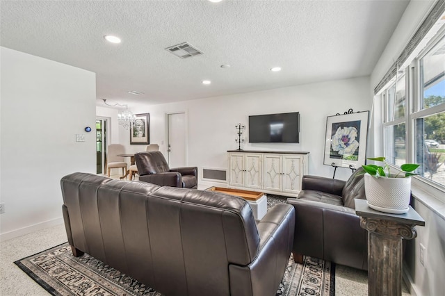 living room with a chandelier, a textured ceiling, recessed lighting, speckle patterned floor, and baseboards