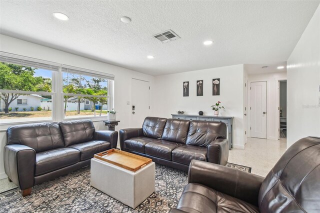 living area with recessed lighting, baseboards, a textured ceiling, and speckle patterned floor