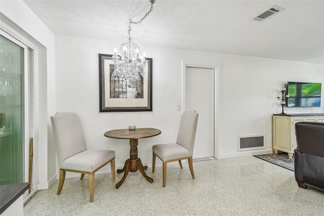 dining room with speckle patterned floor, a chandelier, baseboards, and a textured ceiling