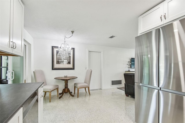 dining space with speckle patterned floor, a chandelier, and baseboards