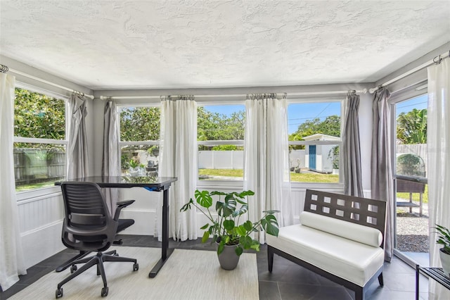 sunroom / solarium with tile patterned flooring and a textured ceiling