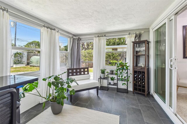 sunroom with a textured ceiling and tile patterned flooring