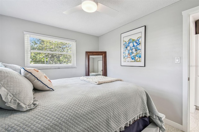 bedroom with carpet floors, a ceiling fan, baseboards, and a textured ceiling