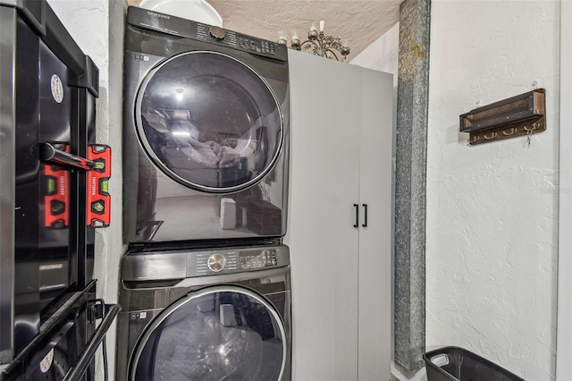 washroom featuring stacked washer / dryer and a textured wall
