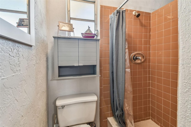 full bathroom featuring a stall shower and toilet