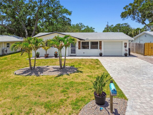 ranch-style home featuring a garage, decorative driveway, and a cooling unit
