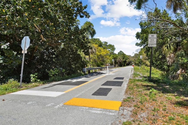 view of asphalt road with traffic signs