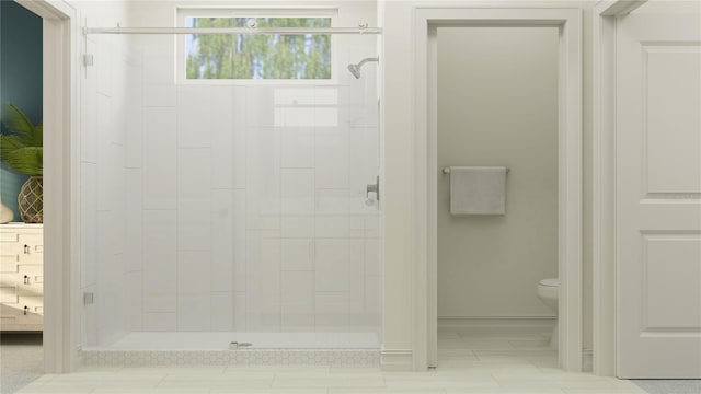 bathroom featuring a shower stall, baseboards, and toilet