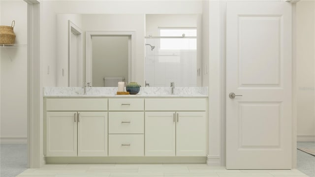 bathroom featuring a stall shower, double vanity, and a sink