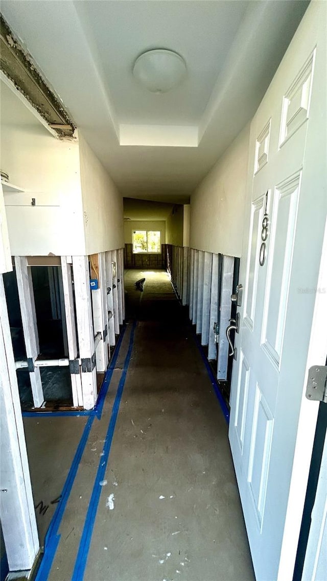 hall featuring a tray ceiling