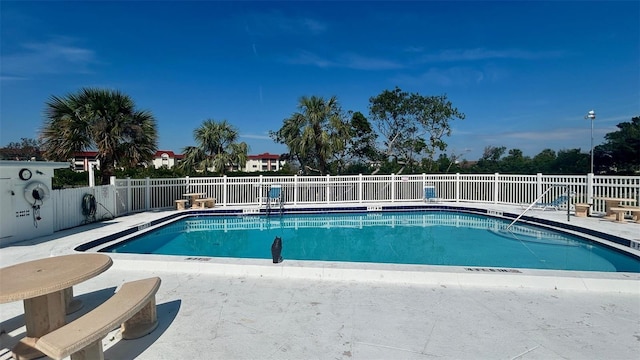 pool with a patio area and fence