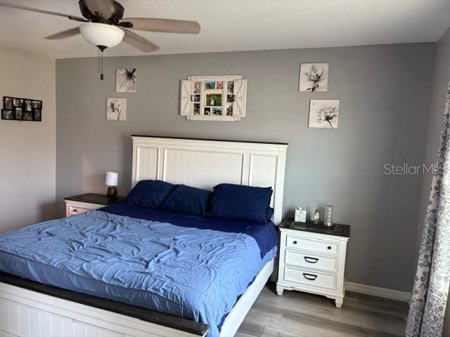 bedroom with wood finished floors, baseboards, and ceiling fan