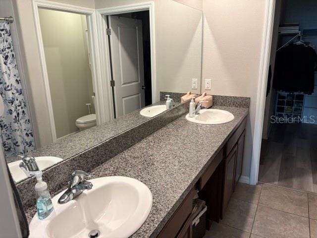 bathroom featuring double vanity, tile patterned flooring, and a sink