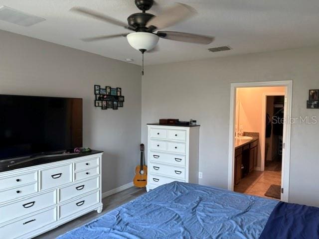 bedroom featuring connected bathroom, visible vents, baseboards, and ceiling fan