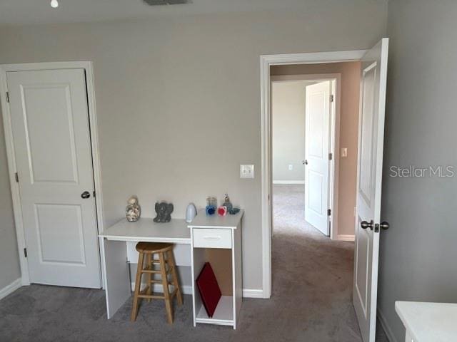 hall with baseboards, carpet flooring, and visible vents