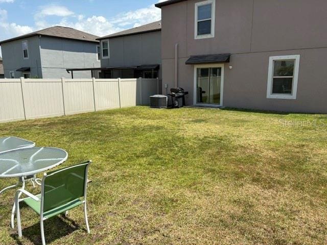 view of yard featuring central AC unit and fence