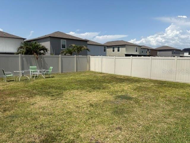 view of yard featuring a fenced backyard and a residential view