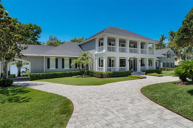 5500 W Lake Butler Rd, Windermere, FL 34786 - greek revival house with covered porch, curved driveway, a front yard, and stucco siding