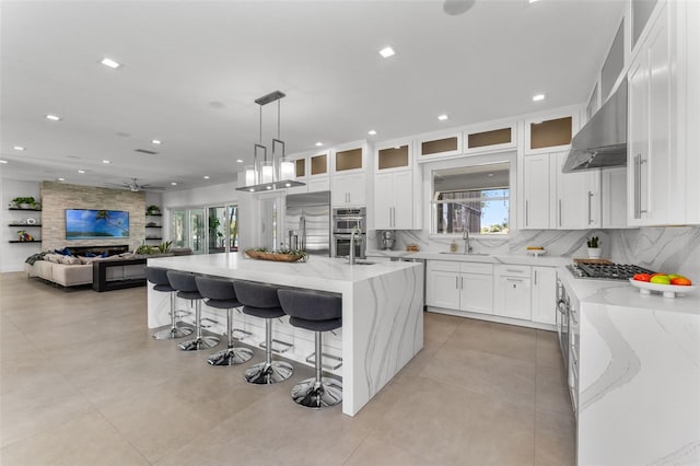 5500 W Lake Butler Rd, Windermere, FL 34786 - kitchen featuring appliances with stainless steel finishes, a sink, decorative backsplash, recessed lighting, and light stone counters