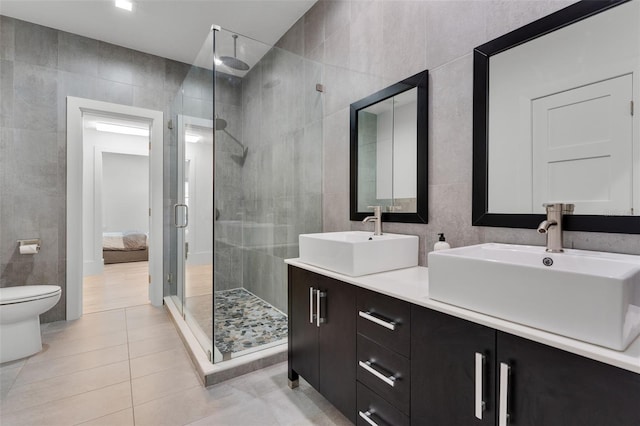 5500 W Lake Butler Rd, Windermere, FL 34786 - bathroom featuring tile walls, a shower stall, double vanity, tile patterned floors, and toilet