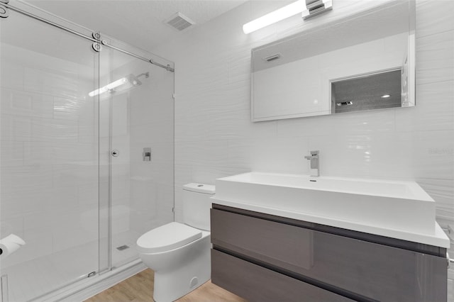 5500 W Lake Butler Rd, Windermere, FL 34786 - bathroom with tile walls, toilet, a shower stall, vanity, and wood finished floors
