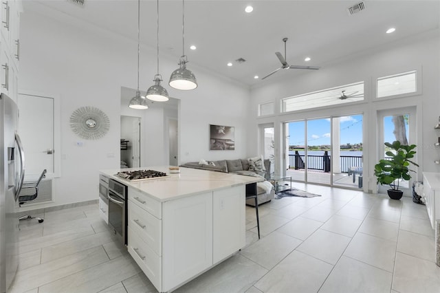 5500 W Lake Butler Rd, Windermere, FL 34786 - kitchen featuring a ceiling fan, a high ceiling, stainless steel appliances, a kitchen island, and white cabinetry
