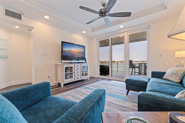living room featuring crown molding, ceiling fan, wood finished floors, recessed lighting, and a tray ceiling
