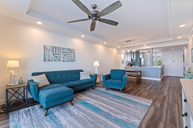 living area with dark wood-type flooring, a tray ceiling, ceiling fan, crown molding, and recessed lighting